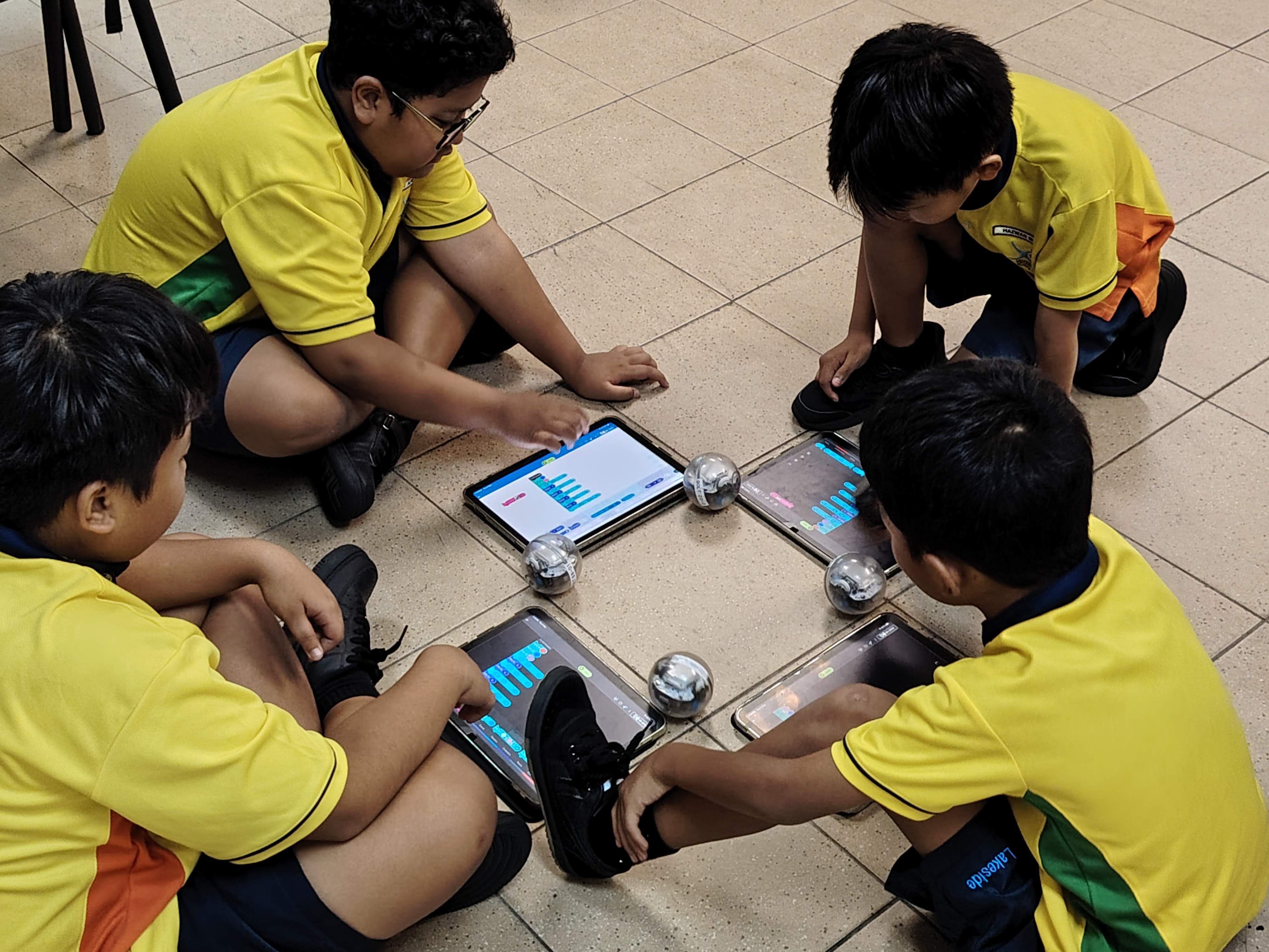 Students working in groups to come up with a choreography for their Spherobots in a Sphero Dance challenge